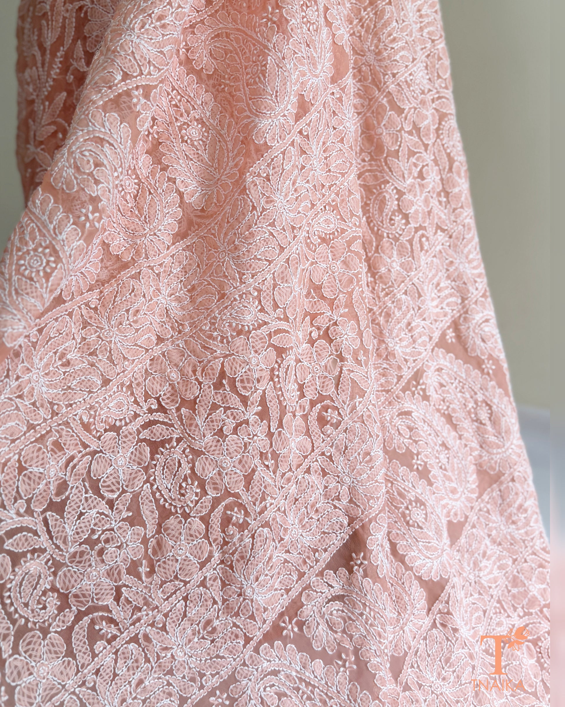 Luxury blush pink Chikankari saree adorned with intricate white thread embroidery and an elegant embroidered pallu.
