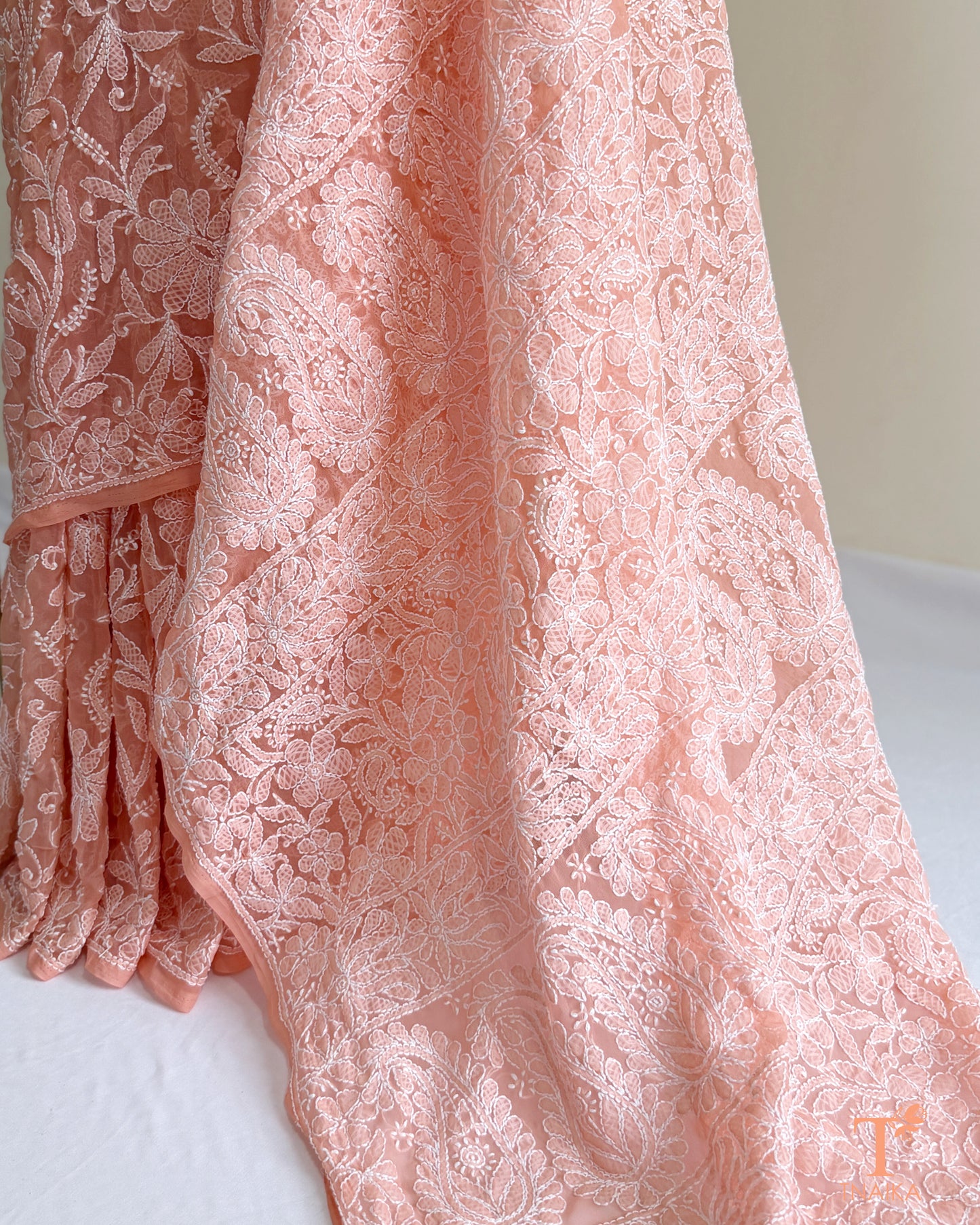 Designer blush pink Chikankari saree with traditional Lucknowi white thread embroidery and delicate floral patterns.