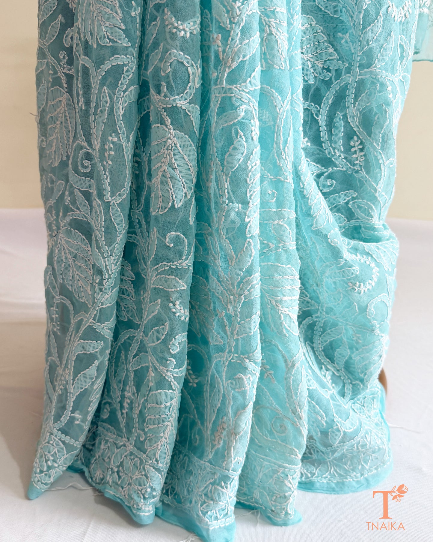 Luxury powder aqua Chikankari saree featuring fine white floral embroidery and graceful all-over handcrafted motifs.