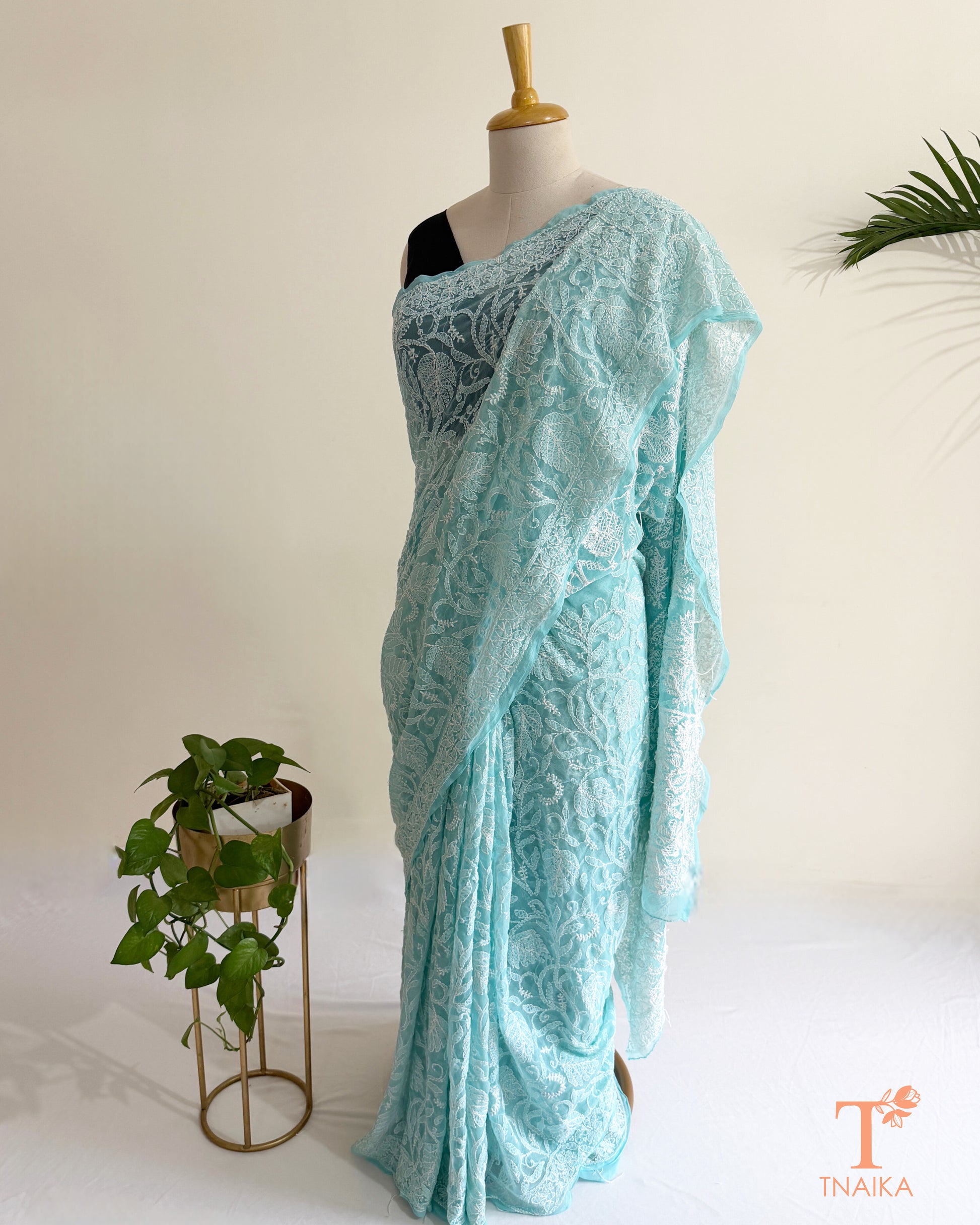 Handcrafted aqua blue Chikankari saree adorned with detailed white thread embroidery and an embroidered pallu.