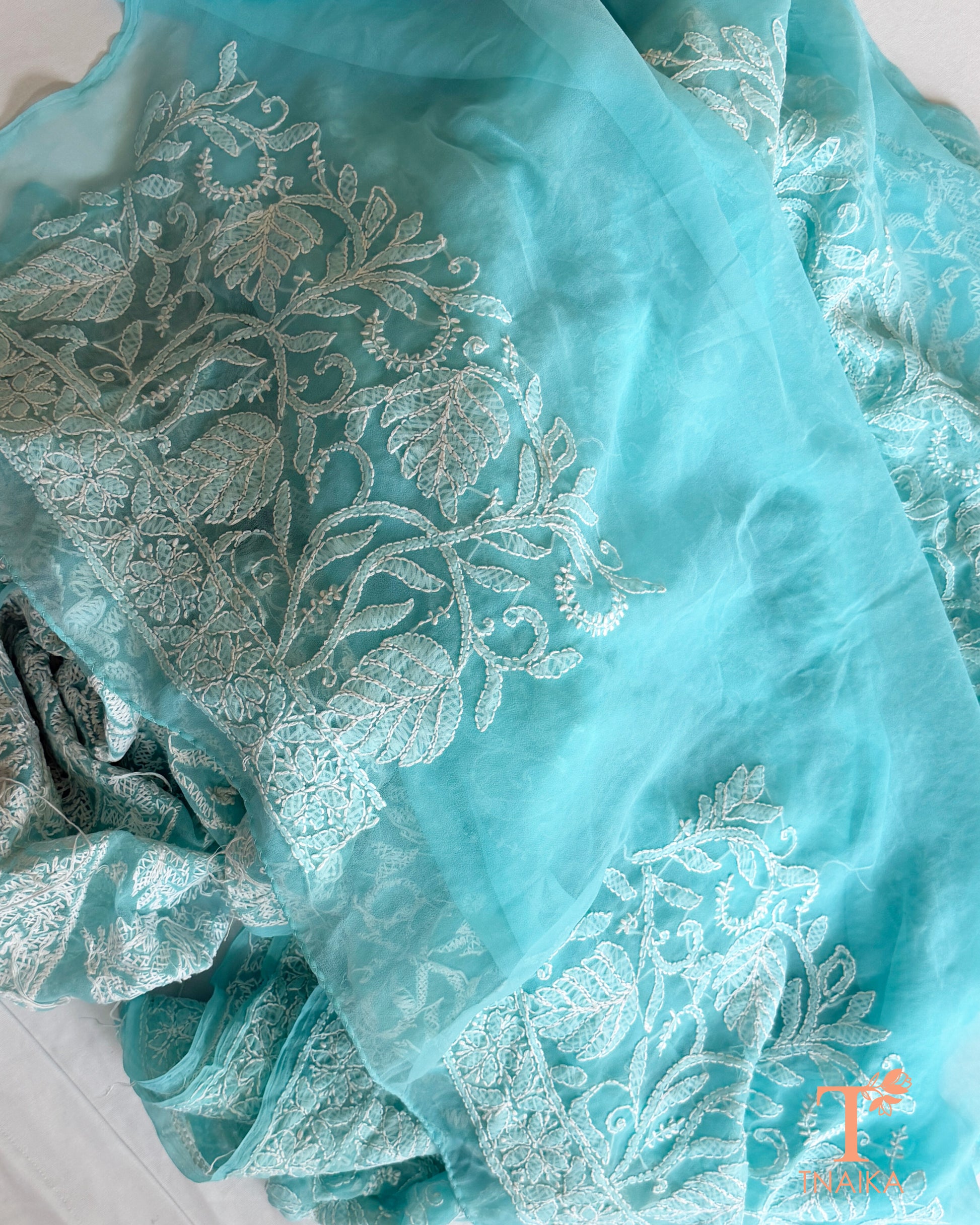 Designer aqua blue Lucknowi Chikankari saree with intricate white thread embroidery and timeless floral craftsmanship.