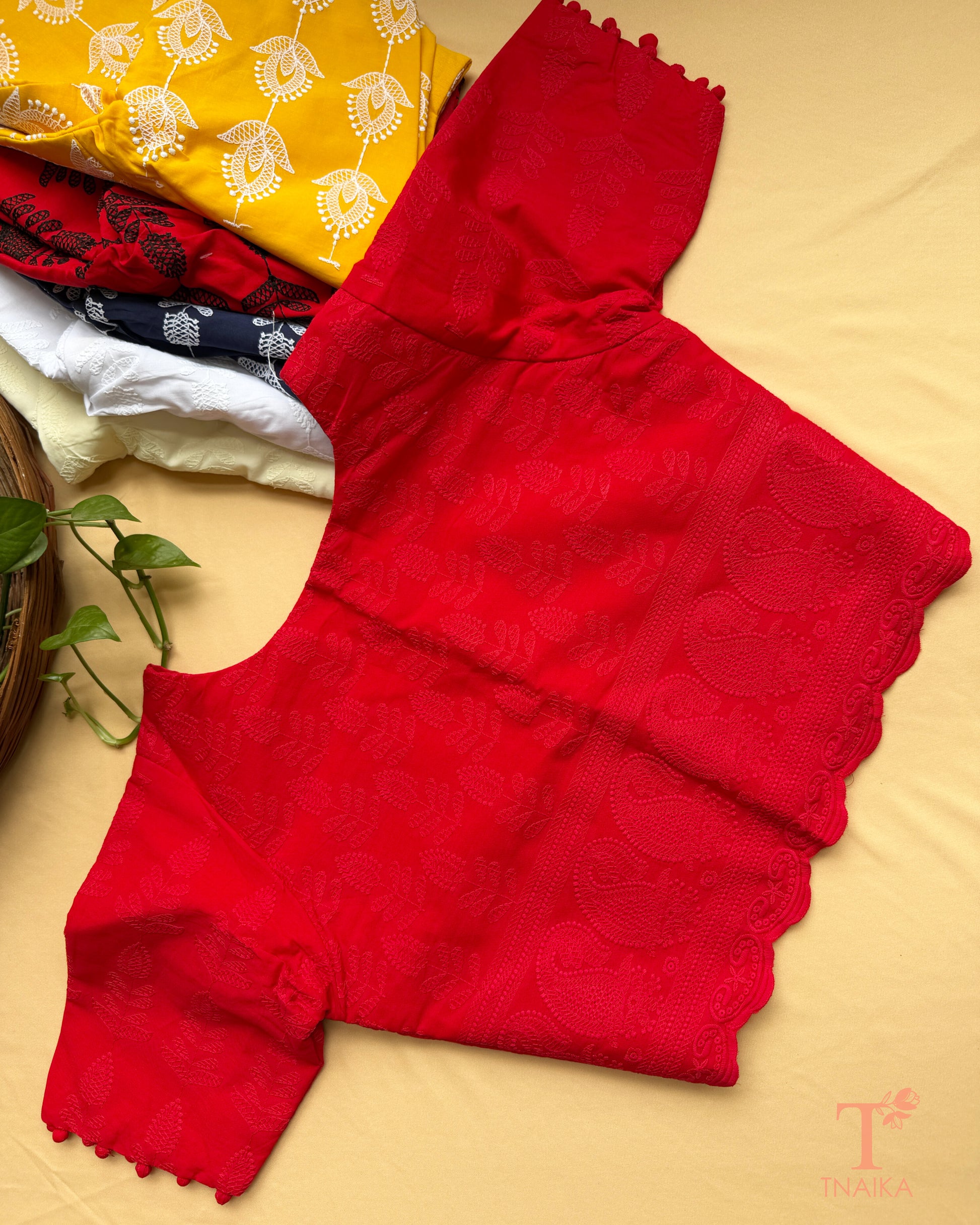 Classic red embroidered blouse featuring machine Chikankari work and decorative potli button sleeve detailing.