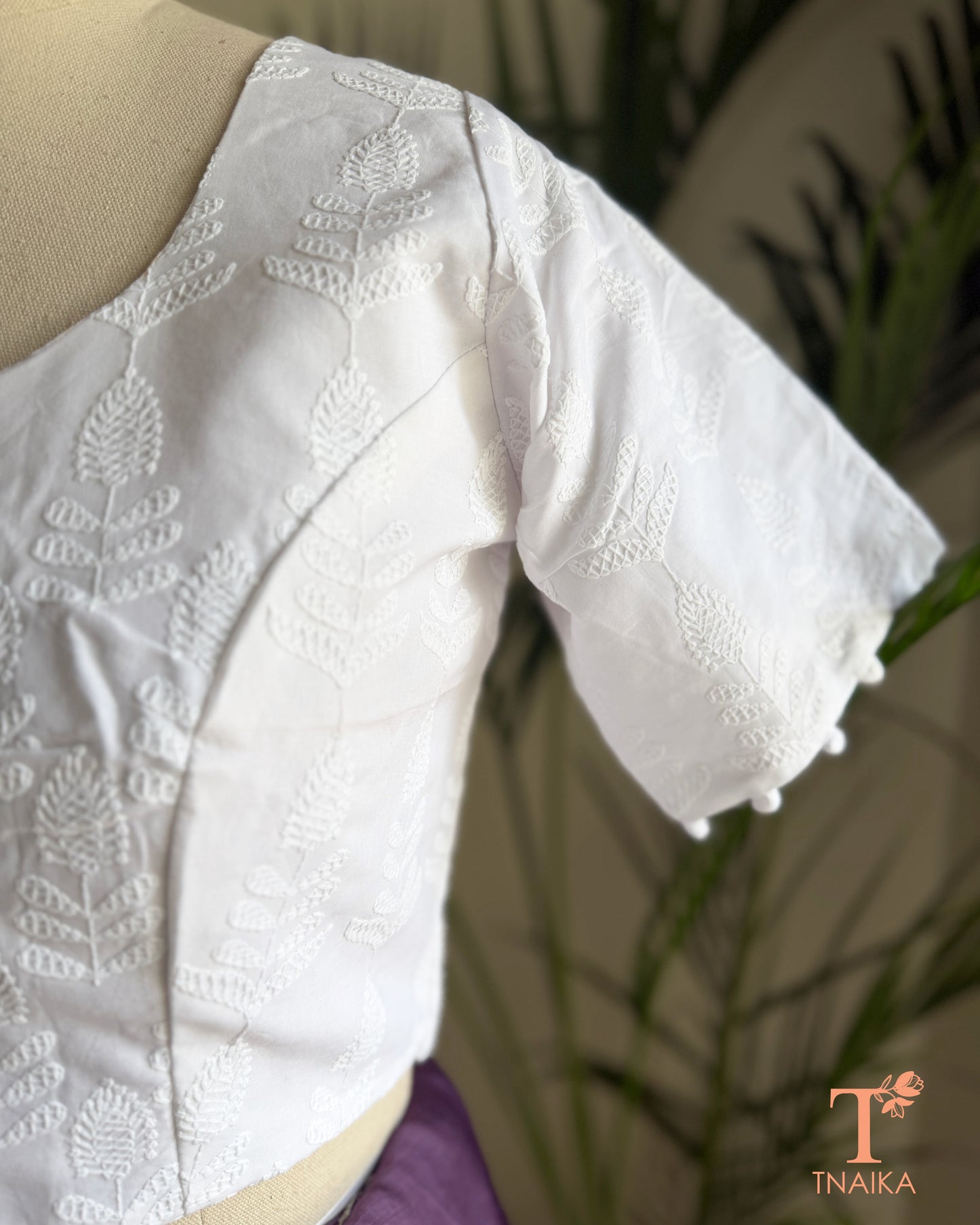 Elegant saree blouse with all-over Chikankari embroidery and decorative potli buttons.