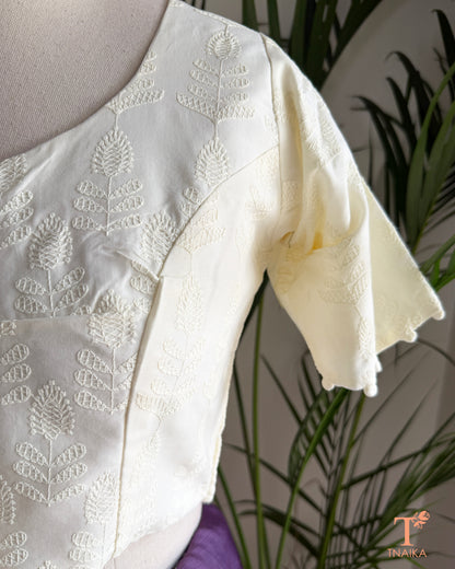 Elegant saree blouse with all-over Chikankari embroidery and decorative potli buttons.