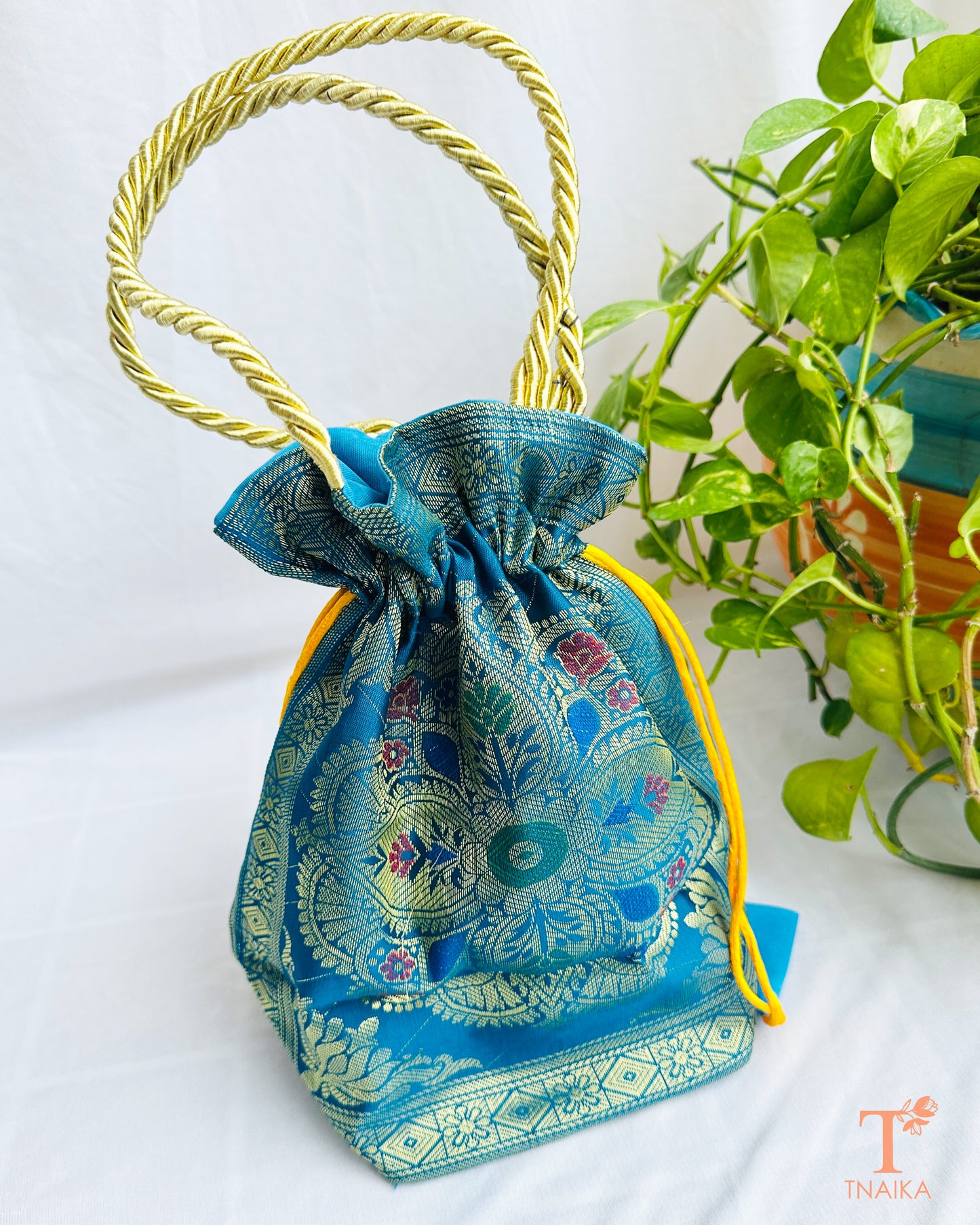 Traditional Banarasi woven fabric convertible handbag featuring dual styling as a tote bag or drawstring potli with rope handles.