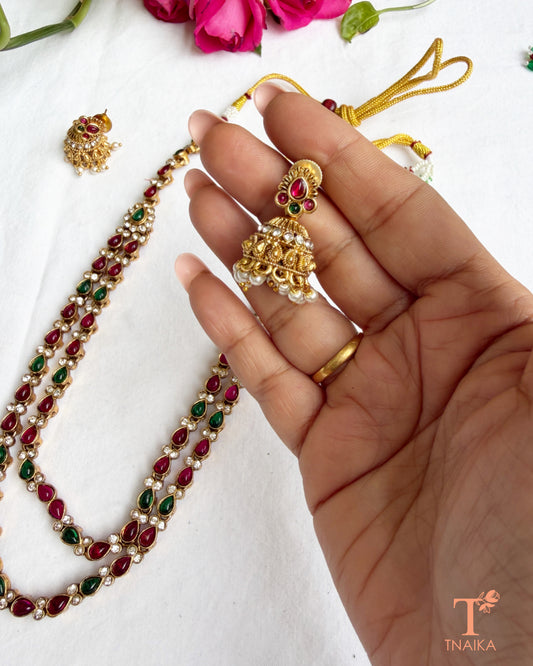 Dual-layer green teardrop stone necklace set with gold polish and traditional jhumki earrings.