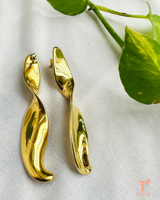 Pair of long gold-tone sculptural earrings showing their smooth curved shape and push-back fastening.
