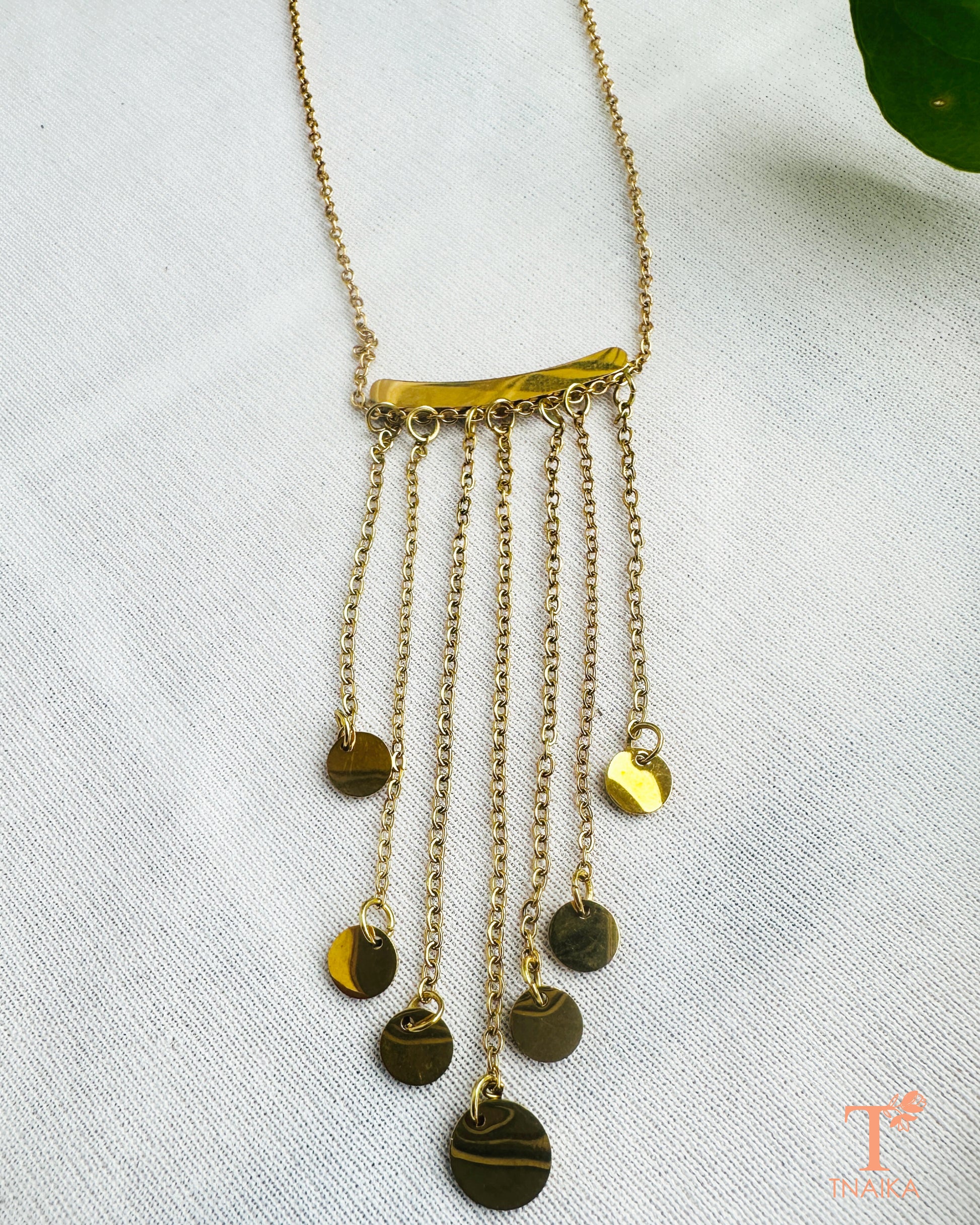Minimal gold tone necklace with cascading chains and round hanging details for everyday and occasion wear.