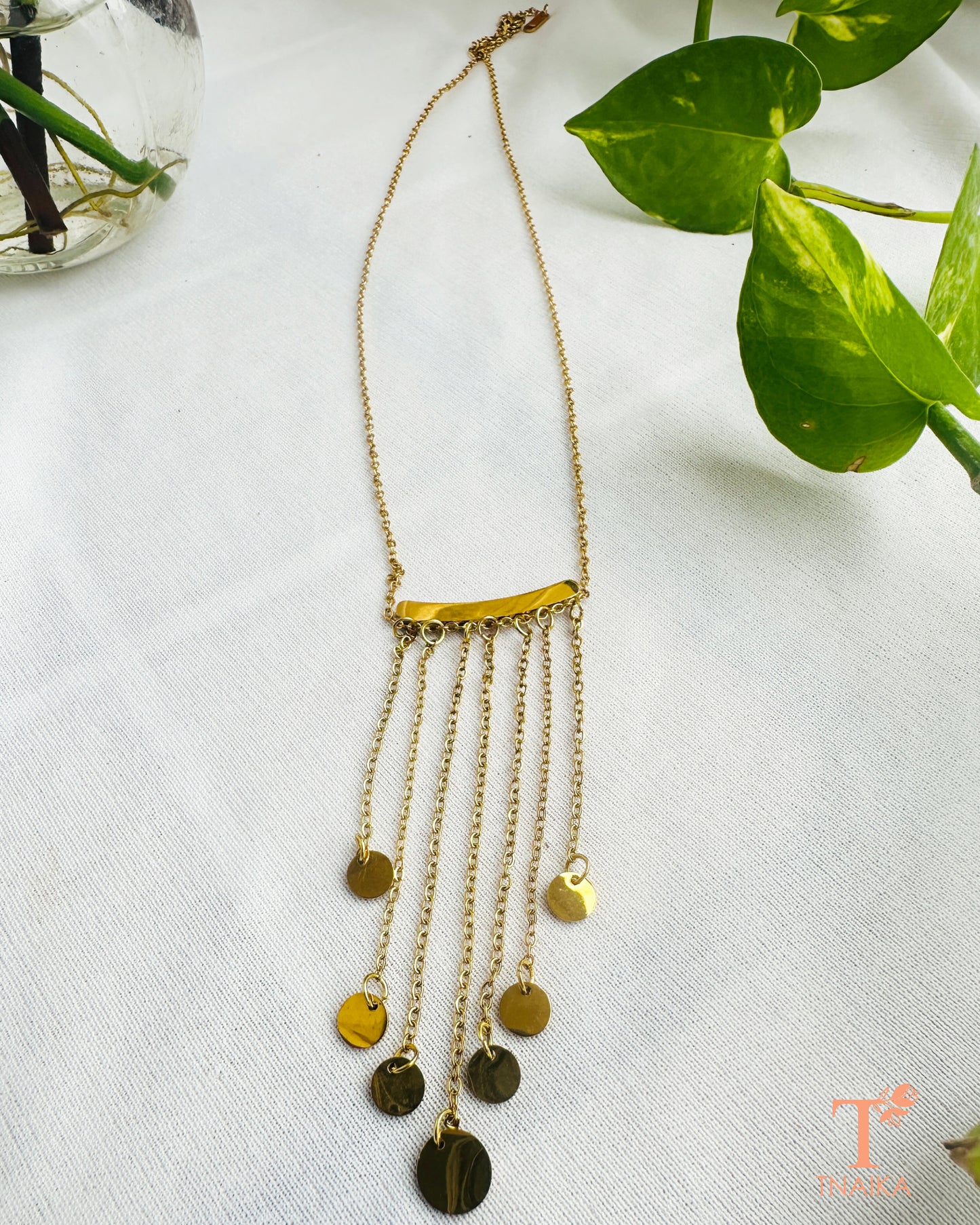 Gold tone anti-tarnish cascading chain necklace with multiple hanging chain layers and round charms.