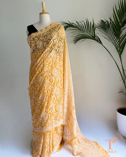 Festive yellow Chikankari saree with richly embroidered border.