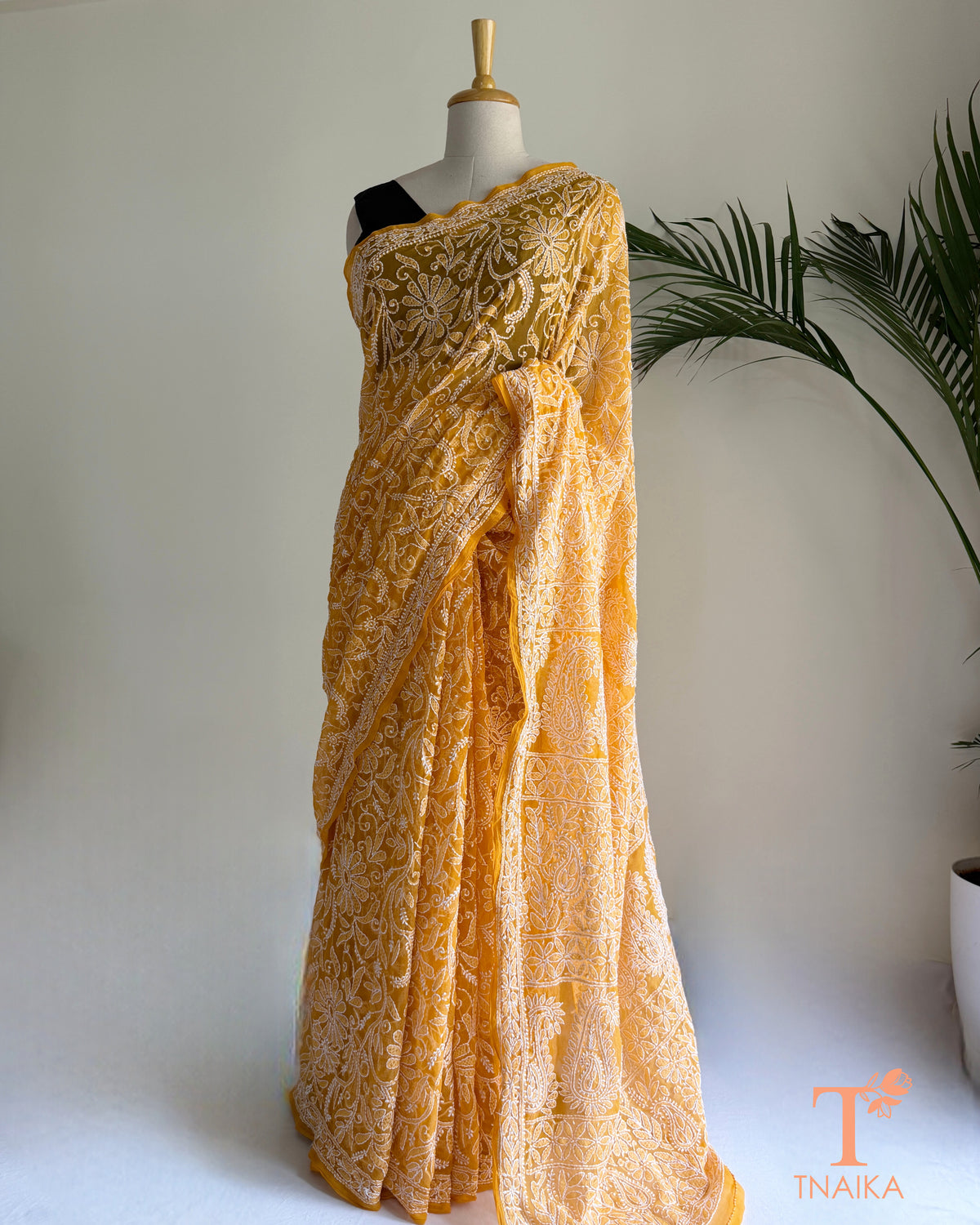Yellow georgette saree with handcrafted paisley and floral embroidery.