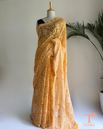 Yellow georgette saree with handcrafted paisley and floral embroidery.