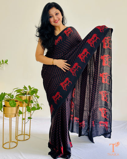 Black modal silk saree with red polka dots and traditional cow motif border