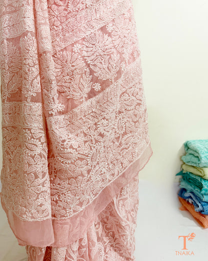 Soft blush pink embroidered saree with handcrafted floral motifs.