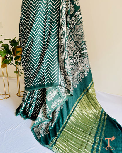 Elegant daytime modal silk leheriya saree with shiny tissue pallu and bold Ajrakh work, with unstitched bandhani printed blouse piece.