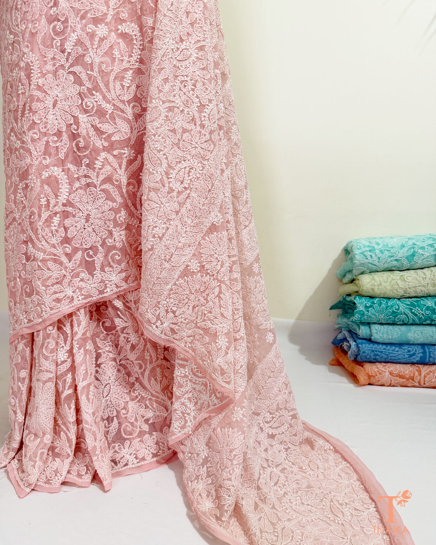 Elegant pink Lucknowi Chikankari saree featuring intricate floral embroidery.